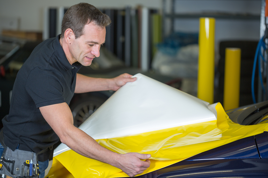 A professional will carefully apply the foil and vinyl wrap to the car